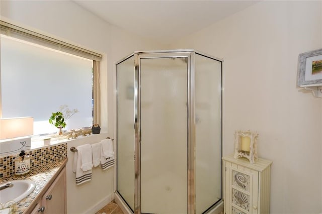 full bathroom with a stall shower, backsplash, and vanity