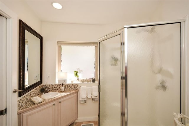 bathroom with a shower stall and vanity