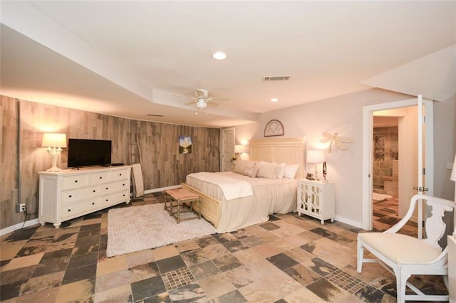 bedroom with wooden walls, baseboards, visible vents, stone finish floor, and recessed lighting