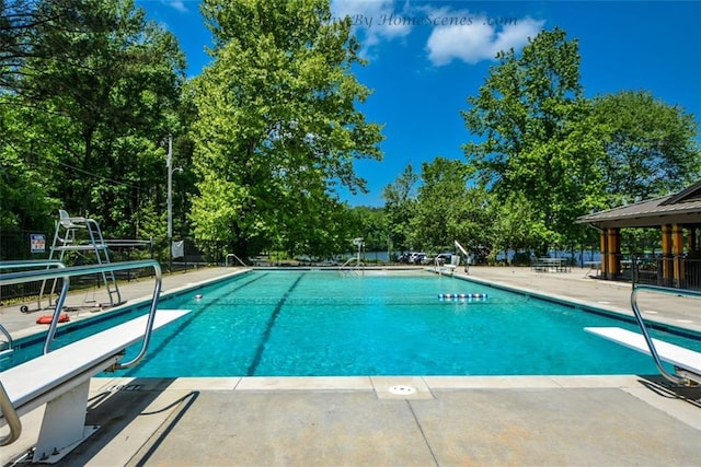 pool with a patio area, a gazebo, and a diving board