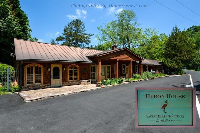 view of front of property with metal roof, a standing seam roof, and stone siding