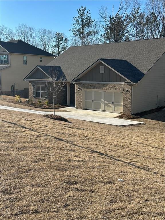 view of front of home with a garage, driveway, board and batten siding, and brick siding