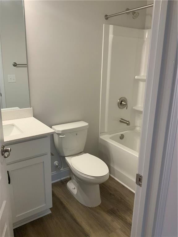 bathroom with toilet, shower / tub combination, wood finished floors, and vanity