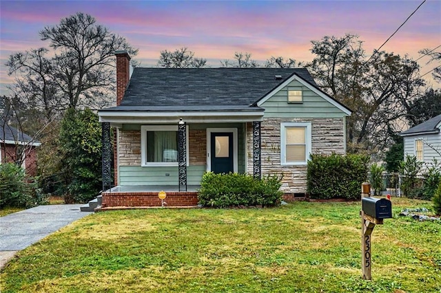 bungalow-style house featuring a porch and a yard