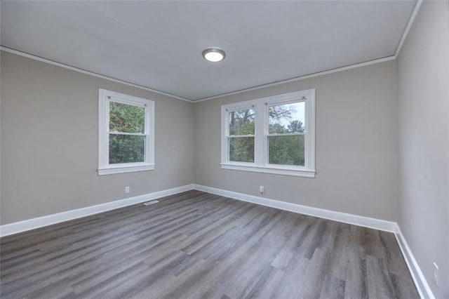 empty room featuring hardwood / wood-style flooring, plenty of natural light, and ornamental molding