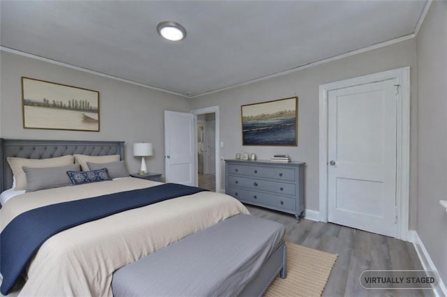 bedroom featuring crown molding and light hardwood / wood-style flooring