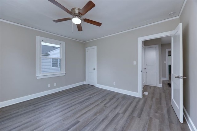 empty room featuring light hardwood / wood-style flooring, ceiling fan, and ornamental molding