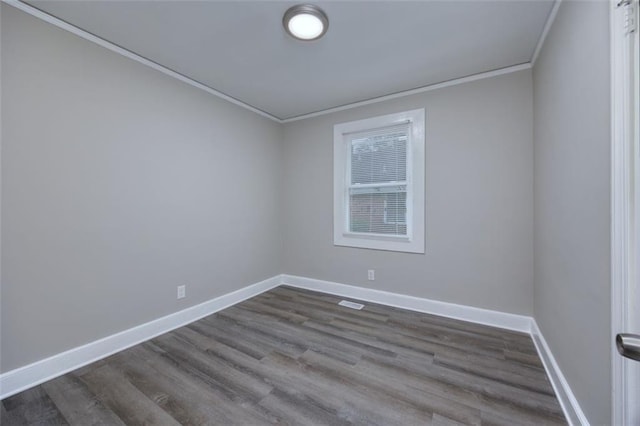 empty room featuring hardwood / wood-style flooring and crown molding