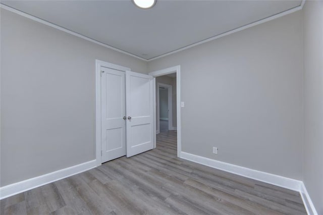 spare room with light hardwood / wood-style flooring and ornamental molding