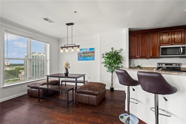 3334 Peachtree Rd NE Unit 1609, Atlanta, GA 30326 - kitchen featuring stainless steel appliances, baseboards, dark wood finished floors, light stone countertops, and ornamental molding