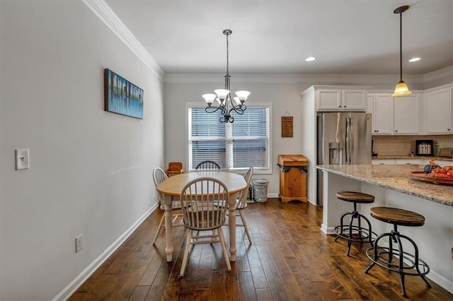 dining area featuring an inviting chandelier, ornamental molding, and dark hardwood / wood-style flooring