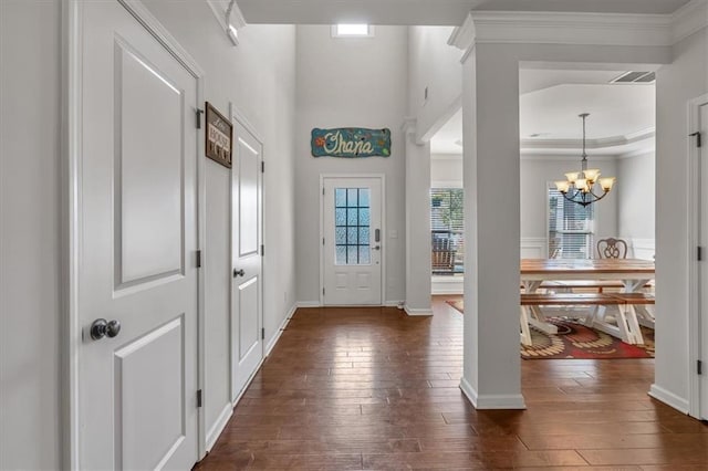 entrance foyer featuring crown molding, dark hardwood / wood-style floors, and a chandelier