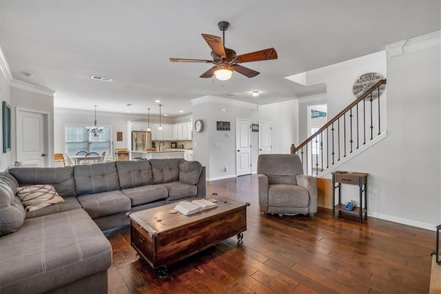 living room with crown molding, dark hardwood / wood-style floors, and ceiling fan with notable chandelier