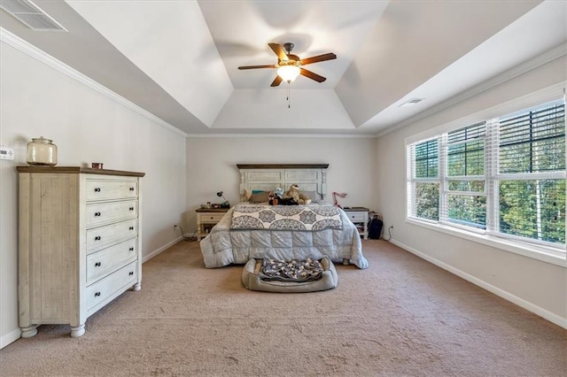 carpeted bedroom with ceiling fan and a tray ceiling