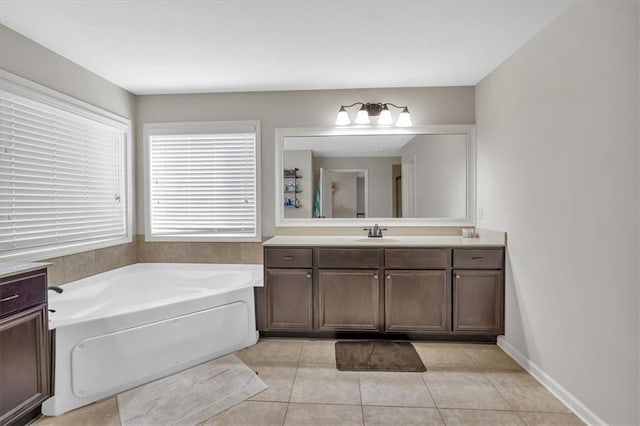 bathroom featuring tile patterned flooring, a tub to relax in, and vanity