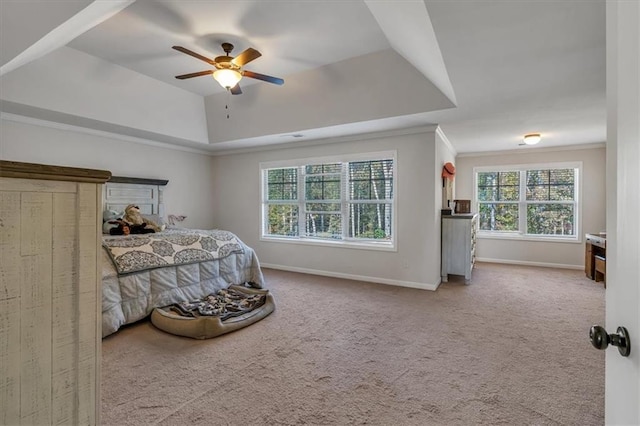 carpeted bedroom featuring ornamental molding, ceiling fan, and a tray ceiling