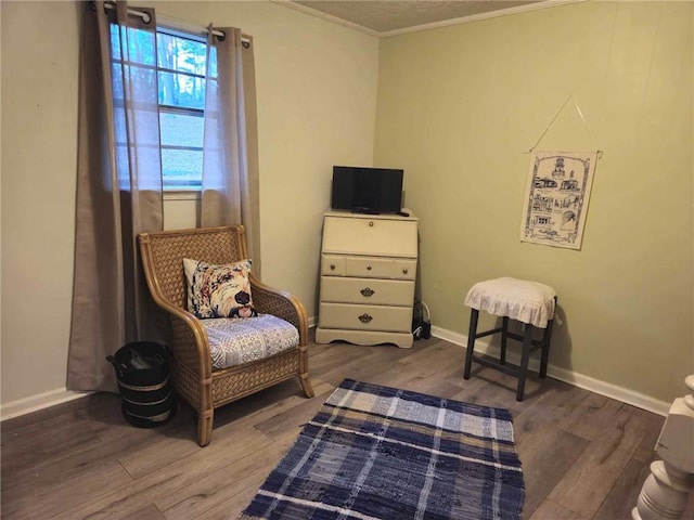 living area featuring wood-type flooring and crown molding