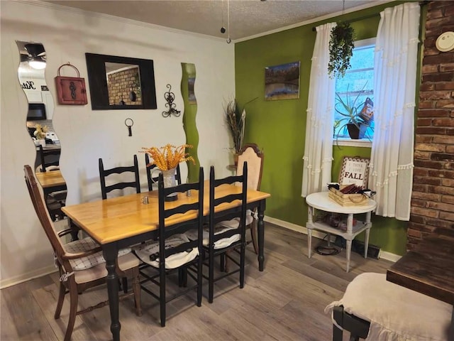 dining space with a textured ceiling, hardwood / wood-style flooring, and ornamental molding