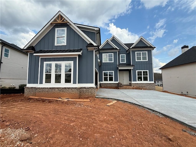 view of front of house featuring board and batten siding, metal roof, and a standing seam roof