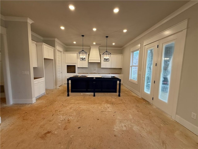 kitchen featuring crown molding, custom exhaust hood, recessed lighting, white cabinetry, and a kitchen island