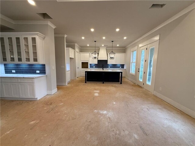 kitchen with white cabinetry, crown molding, and custom exhaust hood