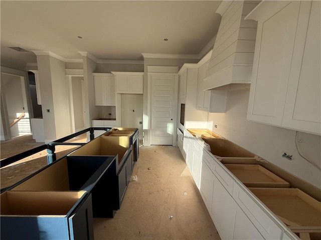 kitchen featuring white cabinetry, crown molding, wall oven, and a kitchen island