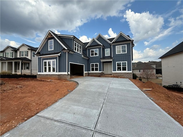 view of front facade featuring a standing seam roof, concrete driveway, a garage, board and batten siding, and metal roof