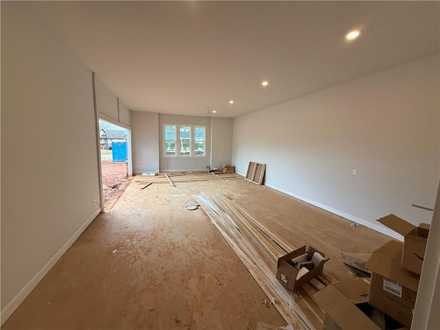 spare room with recessed lighting and baseboards