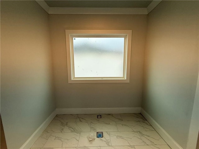 empty room featuring marble finish floor and baseboards