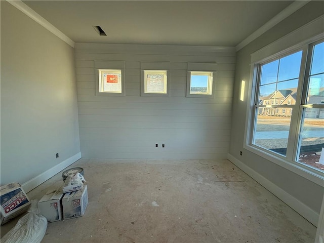 empty room featuring ornamental molding and baseboards