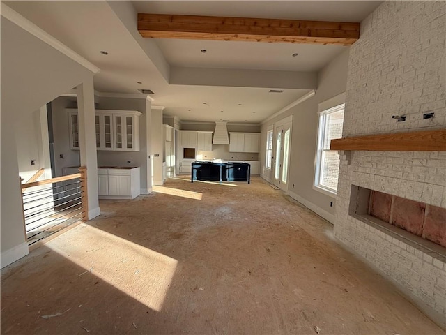 unfurnished living room with crown molding and beamed ceiling