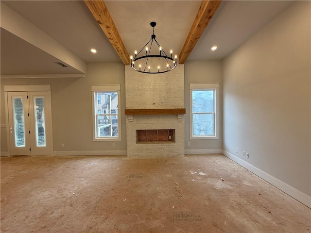 unfurnished living room featuring a brick fireplace, beamed ceiling, plenty of natural light, and baseboards