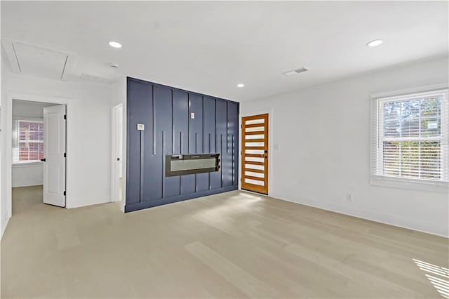 empty room featuring light wood-style floors, recessed lighting, visible vents, and baseboards