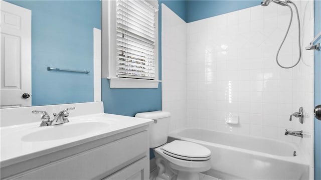 full bathroom with tiled shower / bath, vanity, and toilet