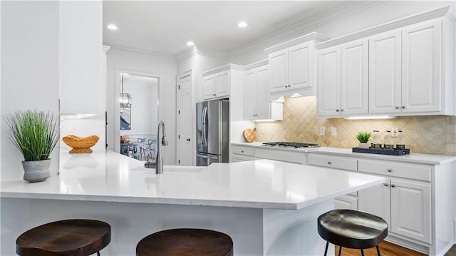 kitchen featuring white cabinetry, tasteful backsplash, a kitchen breakfast bar, and appliances with stainless steel finishes