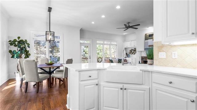 kitchen featuring sink, decorative light fixtures, and white cabinets