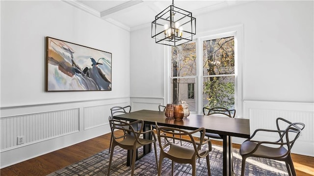 dining room with crown molding, beam ceiling, hardwood / wood-style floors, and a notable chandelier