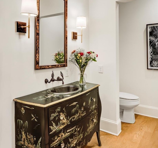 bathroom featuring vanity, hardwood / wood-style floors, and toilet