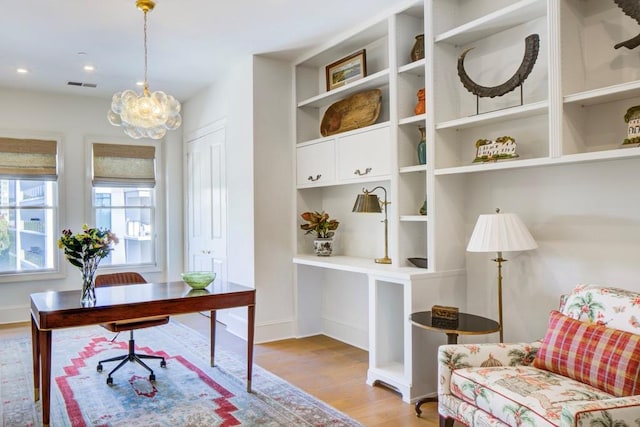 office space with a chandelier and light hardwood / wood-style flooring