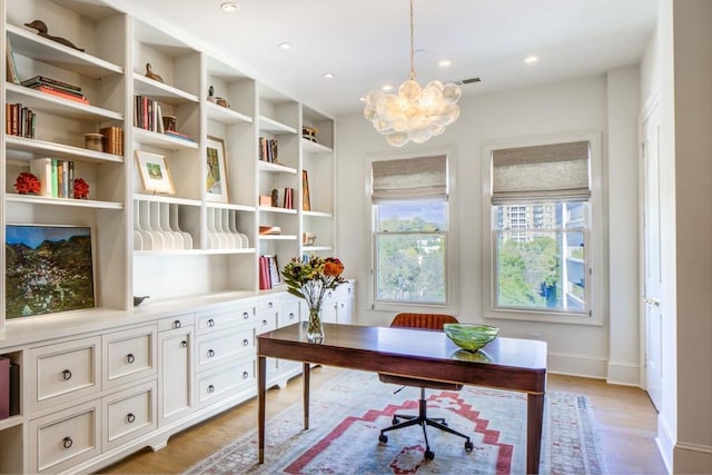 office space featuring an inviting chandelier and light hardwood / wood-style flooring