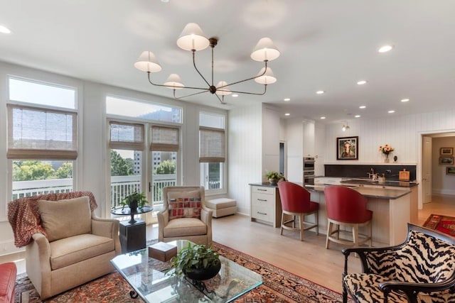 living room with a chandelier and light hardwood / wood-style floors