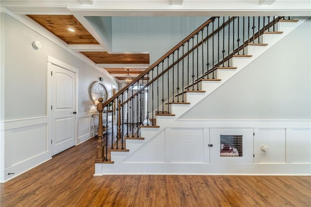 stairway with hardwood / wood-style flooring and wooden ceiling