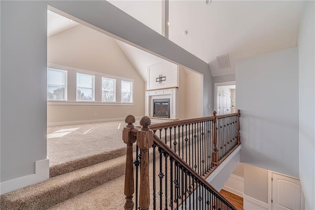 stairway with lofted ceiling and carpet flooring