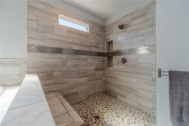 bathroom with tile walls and tiled shower