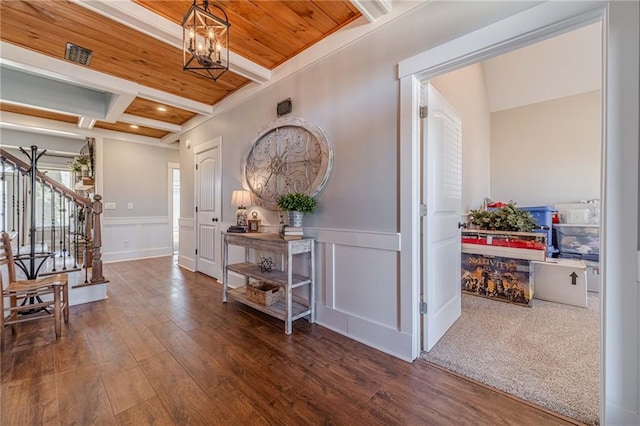 entrance foyer featuring dark wood-type flooring, coffered ceiling, a notable chandelier, wooden ceiling, and beamed ceiling