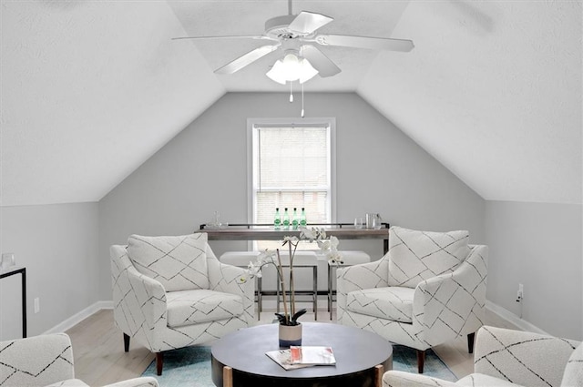 sitting room featuring lofted ceiling, ceiling fan, and light wood-type flooring