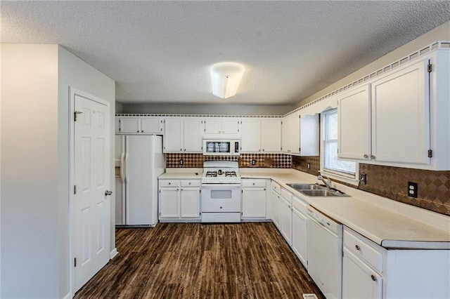 kitchen with white appliances, white cabinets, sink, tasteful backsplash, and dark hardwood / wood-style flooring