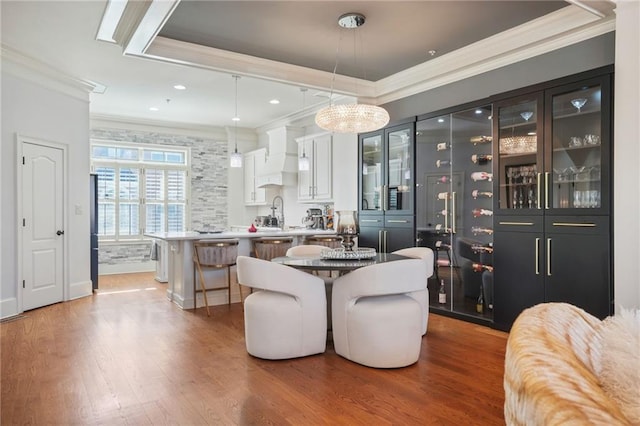 dining space featuring wood finished floors, recessed lighting, and ornamental molding