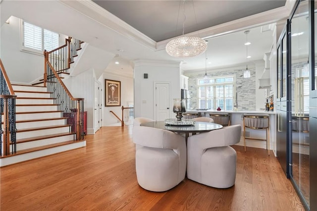 dining area with recessed lighting, stairway, a tray ceiling, light wood-type flooring, and crown molding