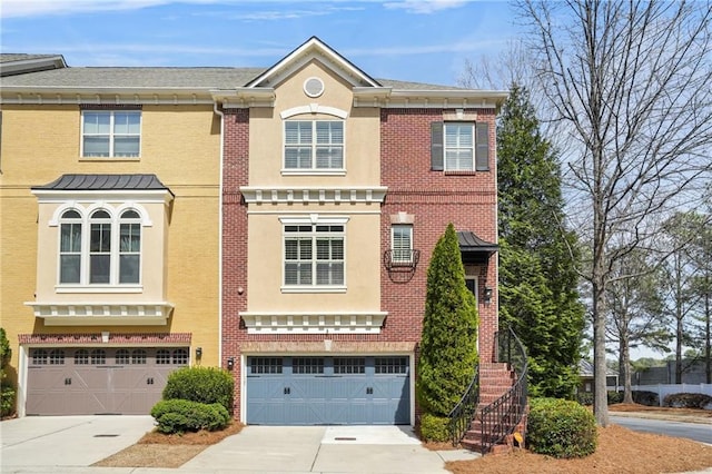 multi unit property featuring a garage, brick siding, stairs, and concrete driveway